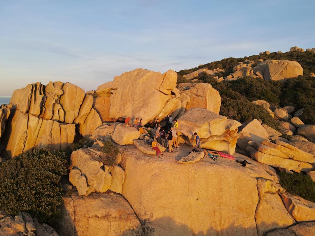 People bouldering at sunset in Sardinia